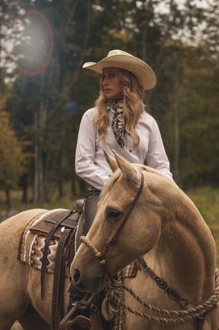 a photo of leatherworker Aprille Tomlinson riding a horse