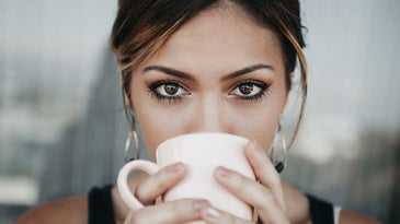 A brown-eyed individual holding a mug
