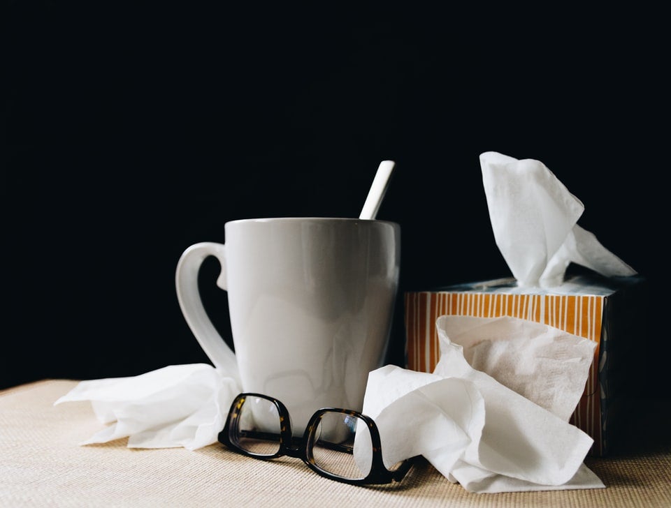 a mug next to a pile of tissues