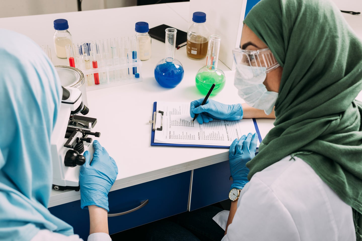 Masked researchers handling samples
