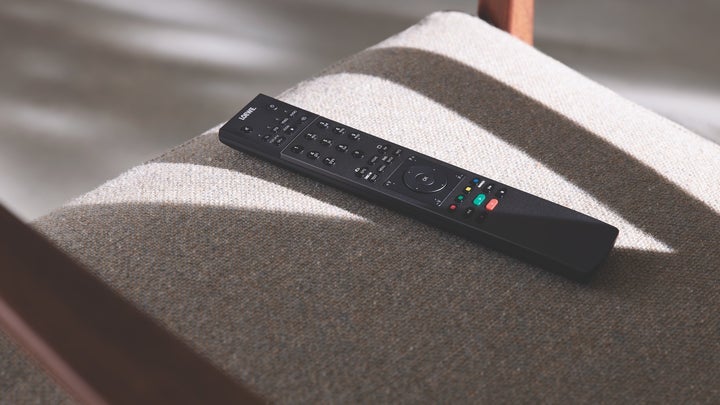 a black TV remote on a gray chair