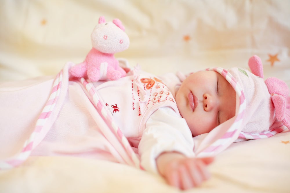 Sleeping baby with small teddy bear