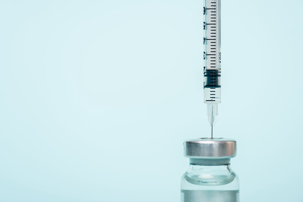 A syringe in a vaccine bottle