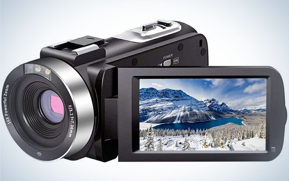 A black and silver professional camera with a small desktop with a mountain view in it.