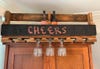 a wall-mounted wine rack made out of a reclaimed wood pallet, with a chalkboard and a wine glass holder