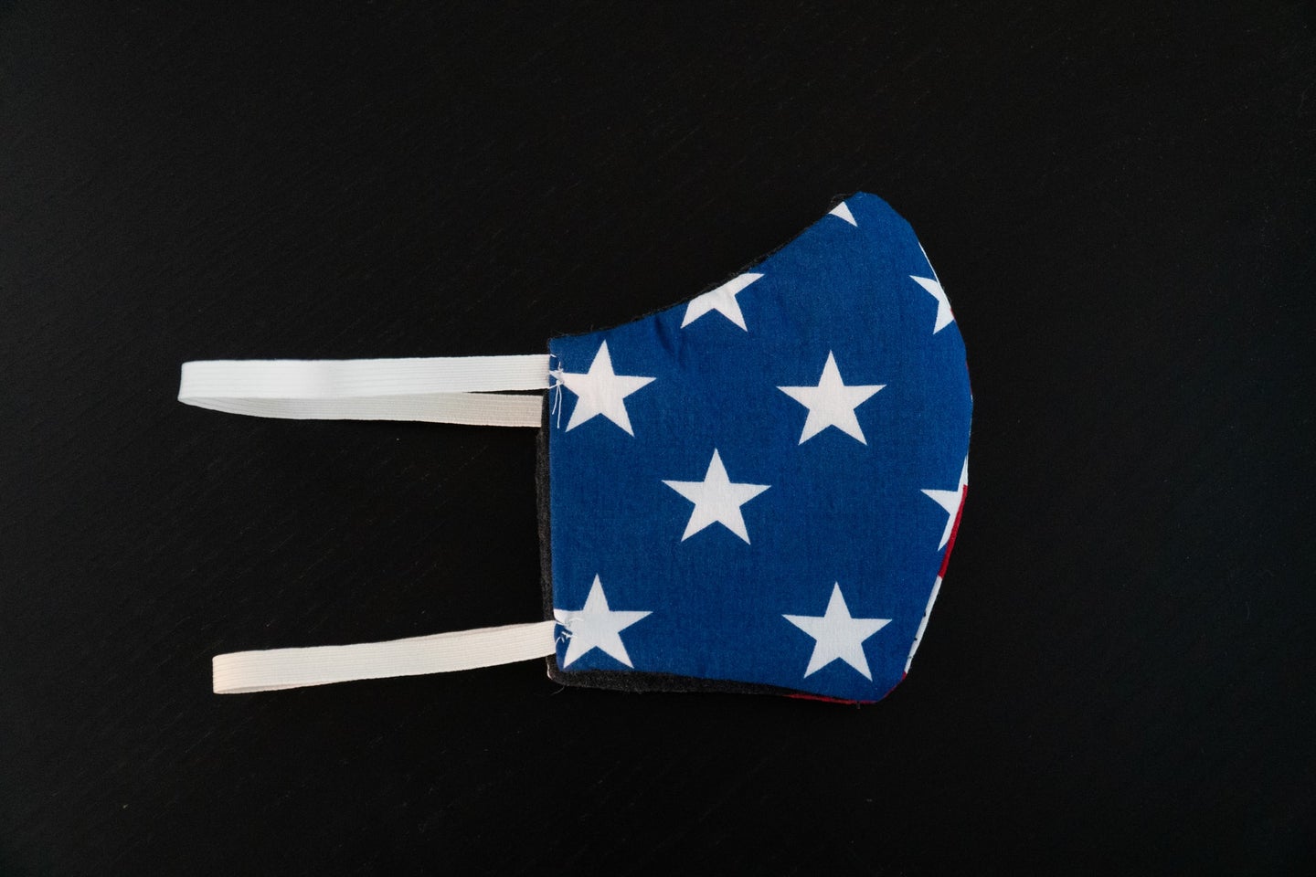 an american flag face mask on a black background