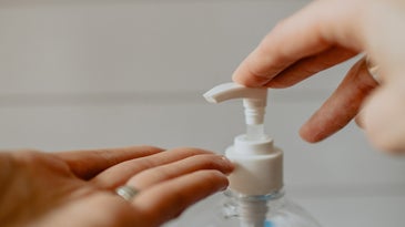 Hand sanitizer bottle and hands.