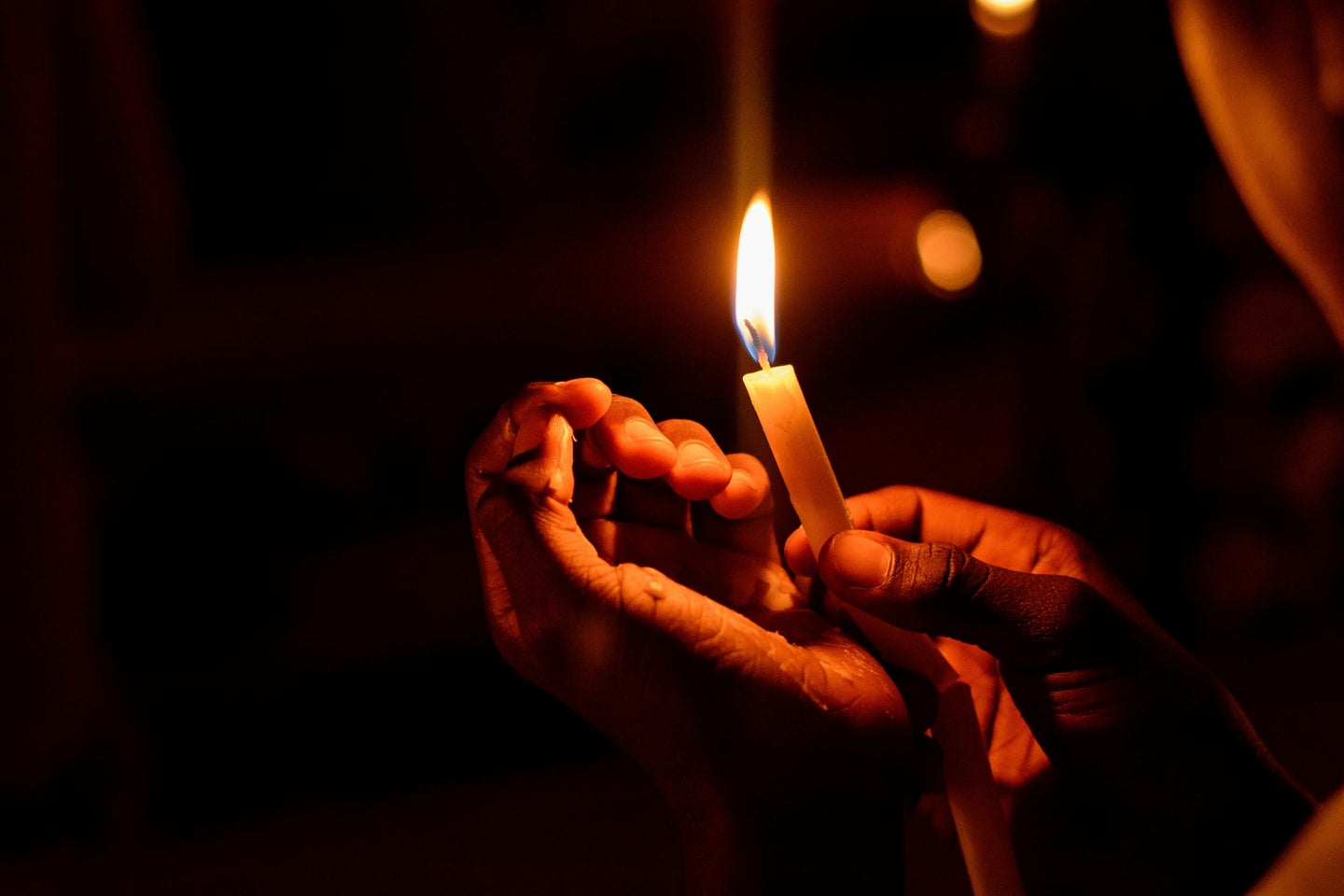 Hands holding candle.