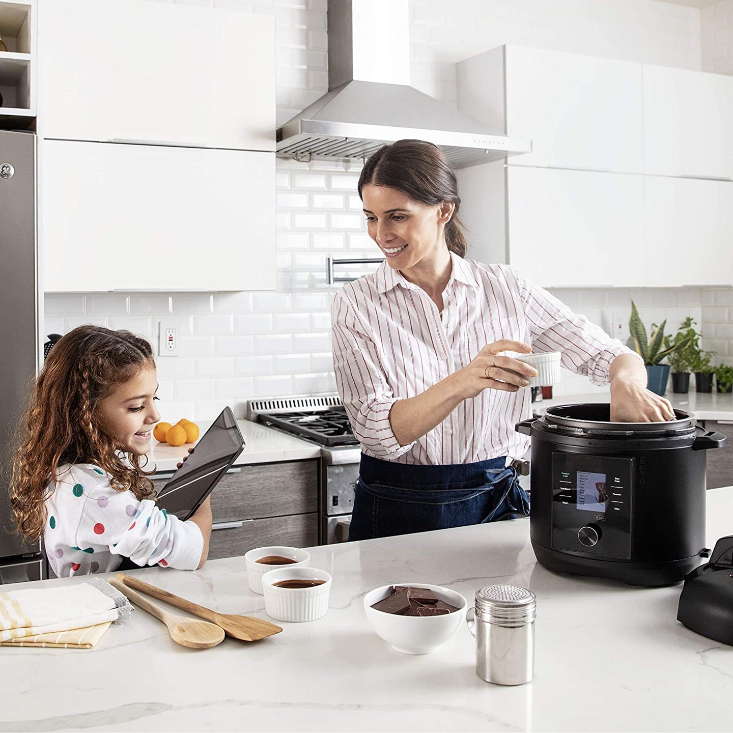 mother and daughter making food in multi-cooker