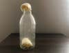 a photo of a hard-boiled egg partially inside a glass bottle as part of a science experiment