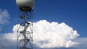 A weather radar station in South Dakota with a thunderstorm in the background