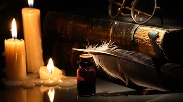 A still life of books, a quill, old spectacles, and candles