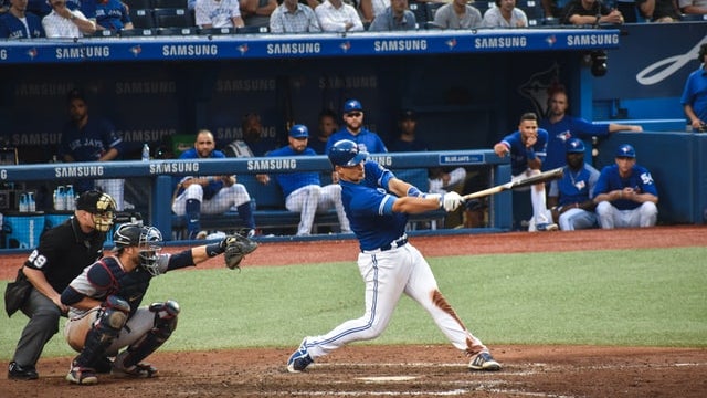 a baseball player swings a bat