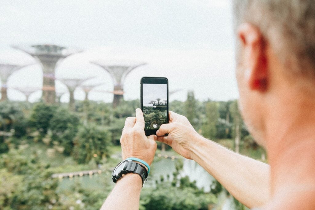 a man taking a photo of some buildings in Singapore