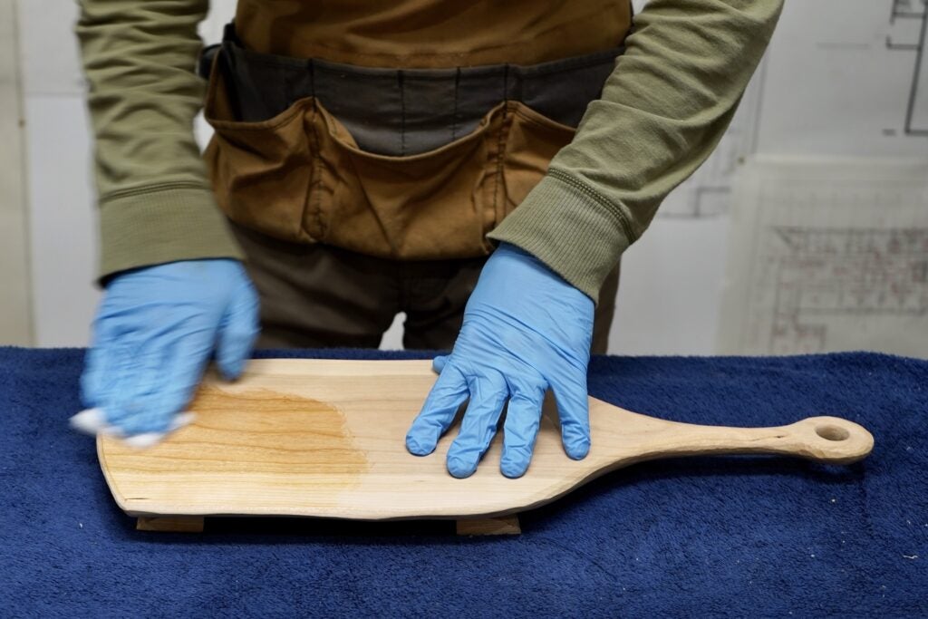 a person applying finish to a homemade cutting board
