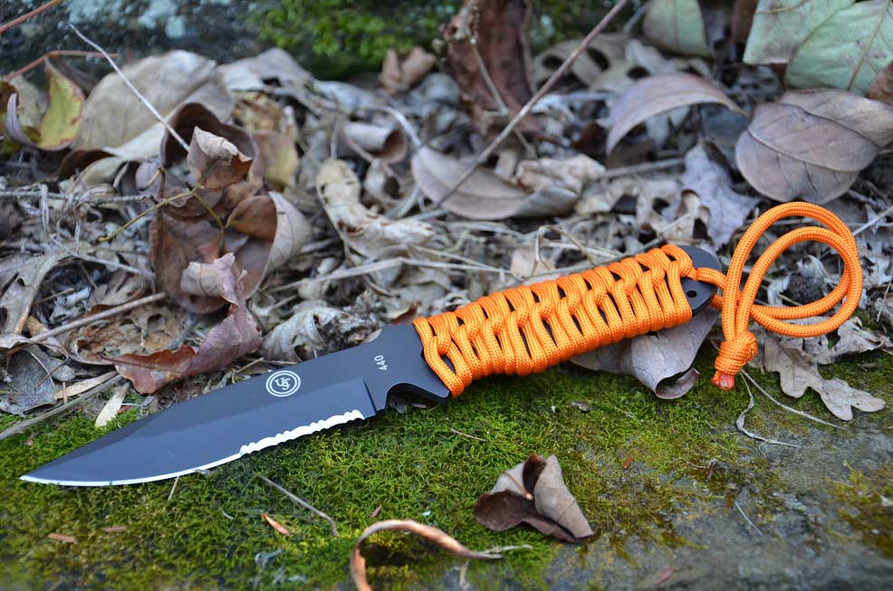 A knife sitting in a pile of leaves.