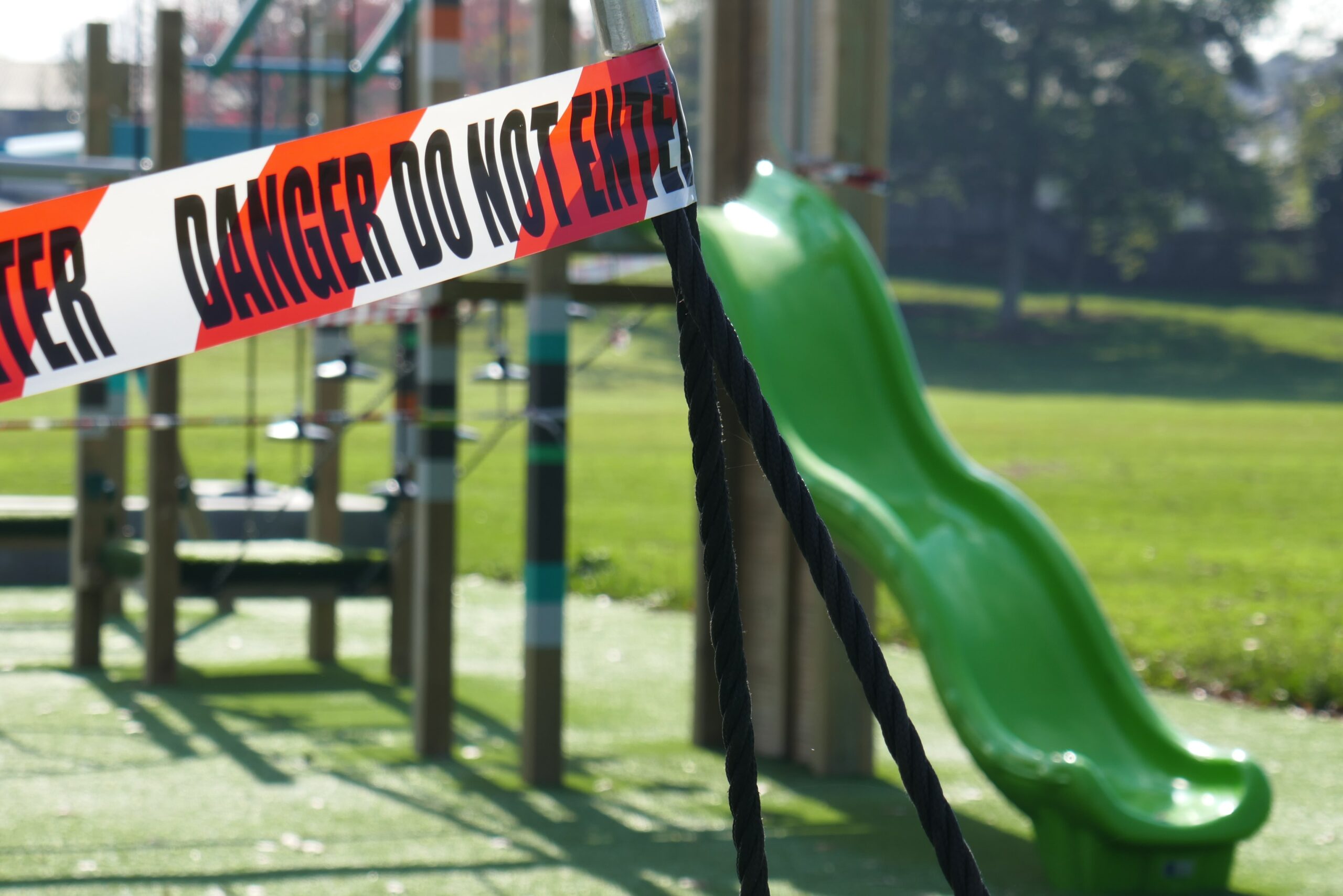 a playground with tape around it that reads "danger, do not enter"