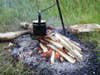 A campfire cookstove over a burning fire.