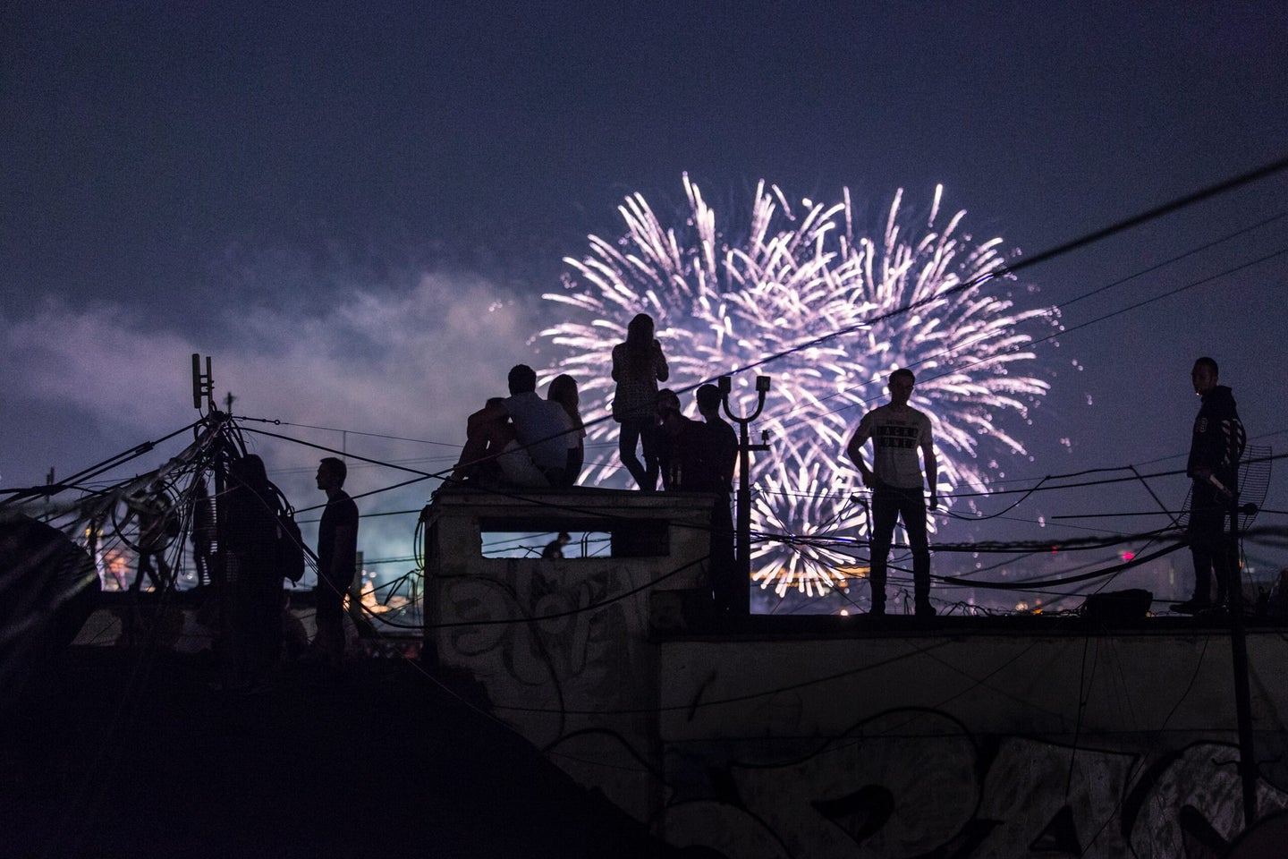 A group watching fireworks from a roof