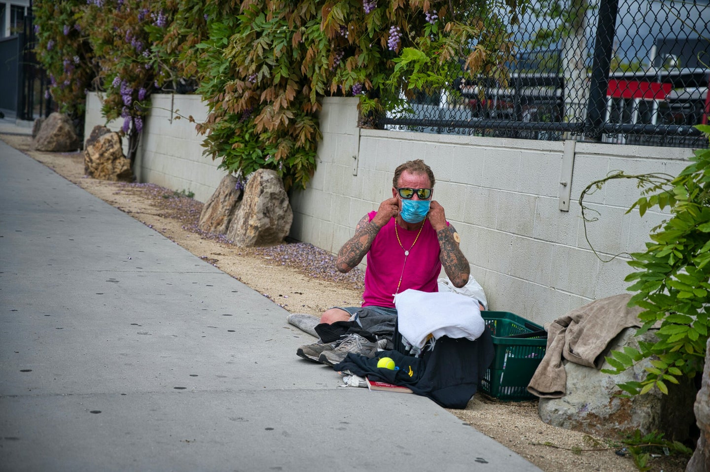homeless man puts on face mask