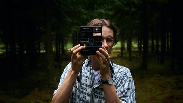 person holding instant camera