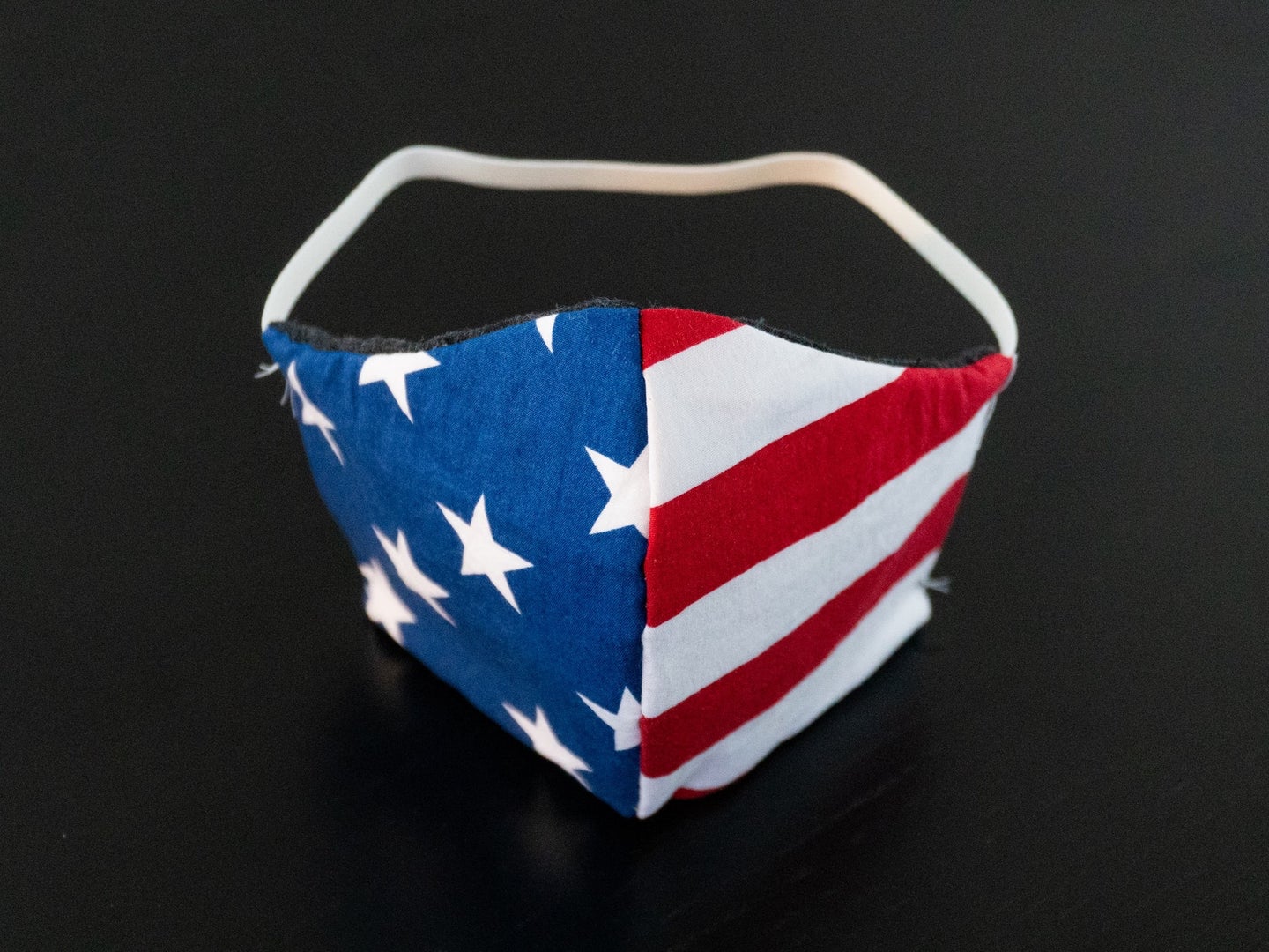 an American-flag patterned face mask on a black background.