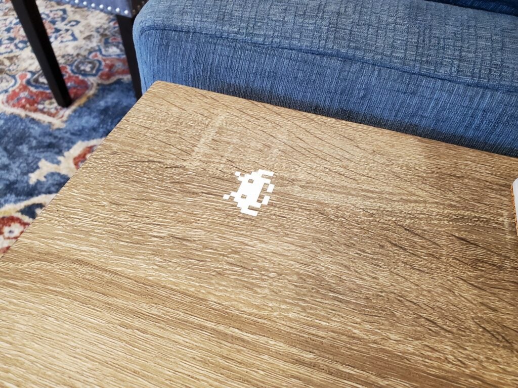 a Space Invaders decal on a table with built-in wireless charging