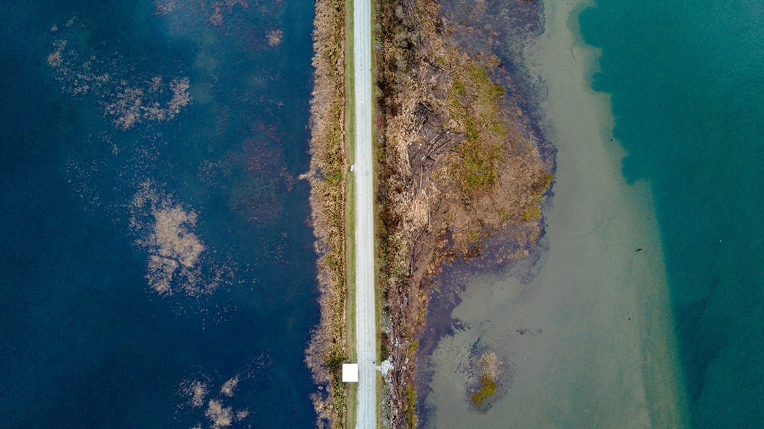 drone shot of road and ocean