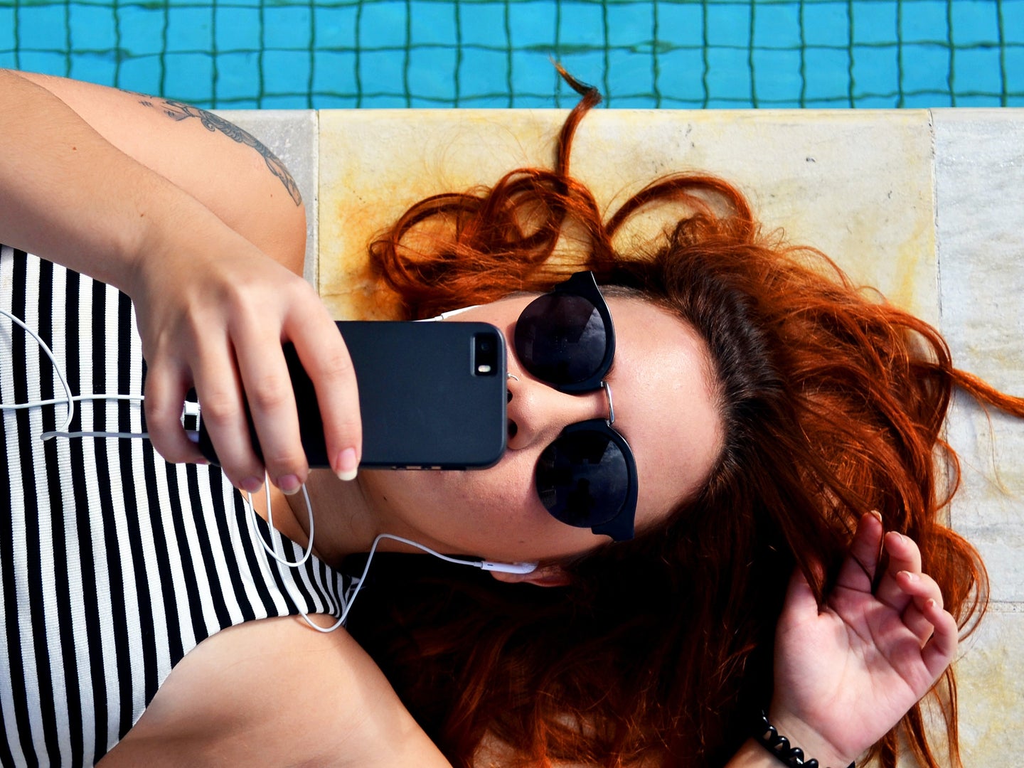 Person looking at phone by the pool