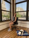 Woman rotating neck while sitting in chair