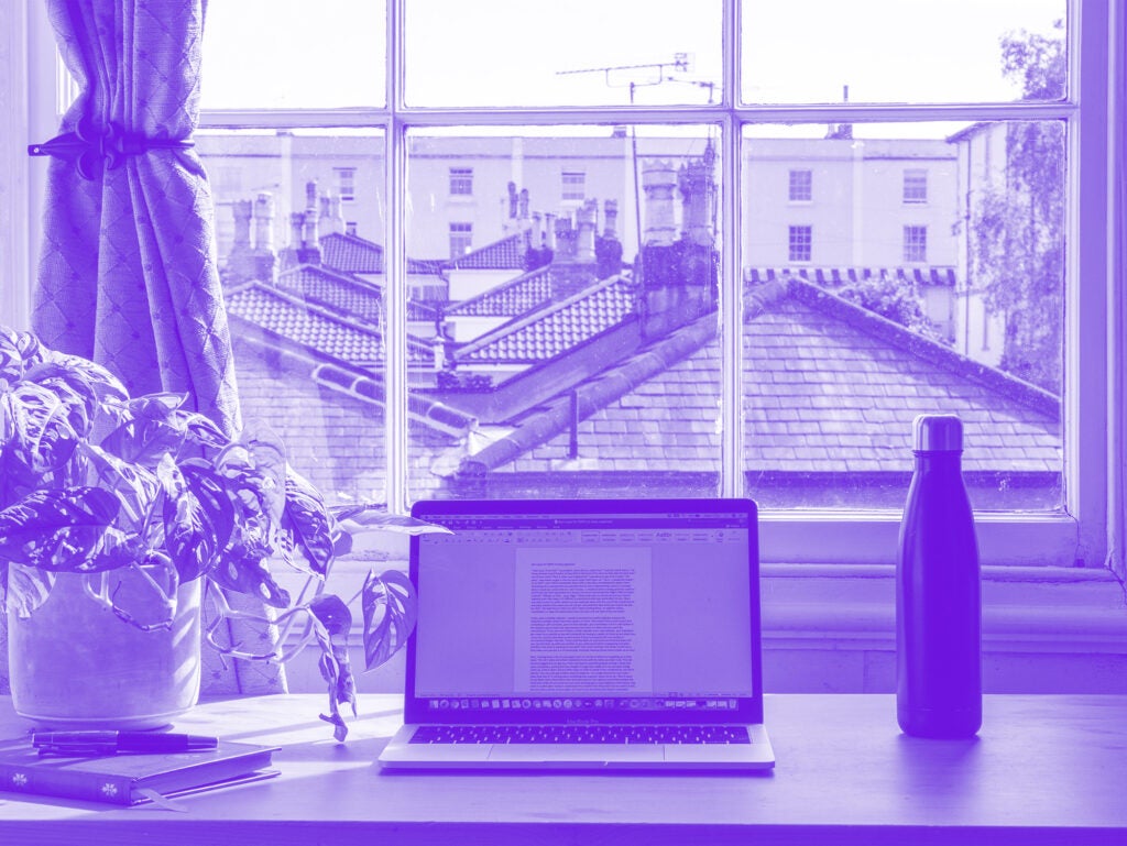purple monochrome photo of laptop on desk looking out window