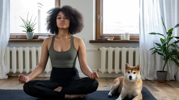 Girl doing yoga with dog.