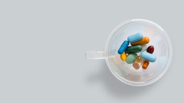 A cup full of multi-colored pills