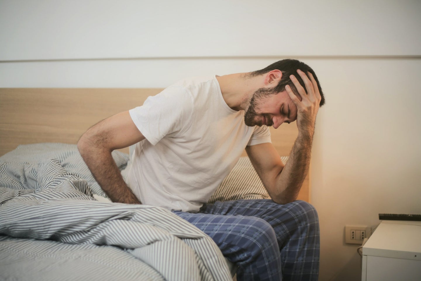 Man with headache on bed.