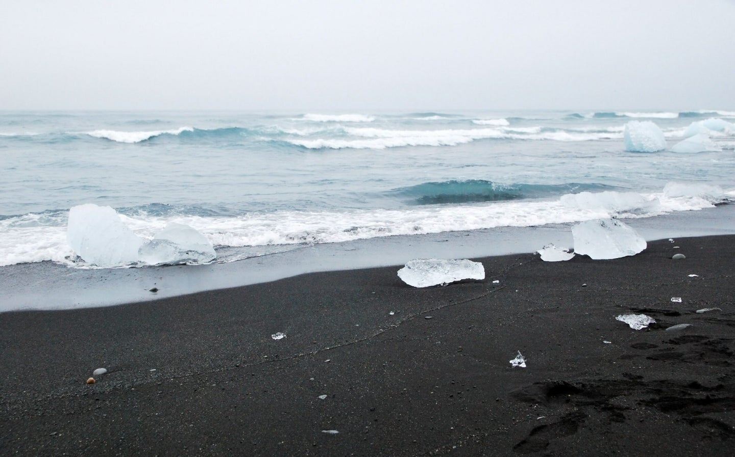 black sand beach with chunks of ice