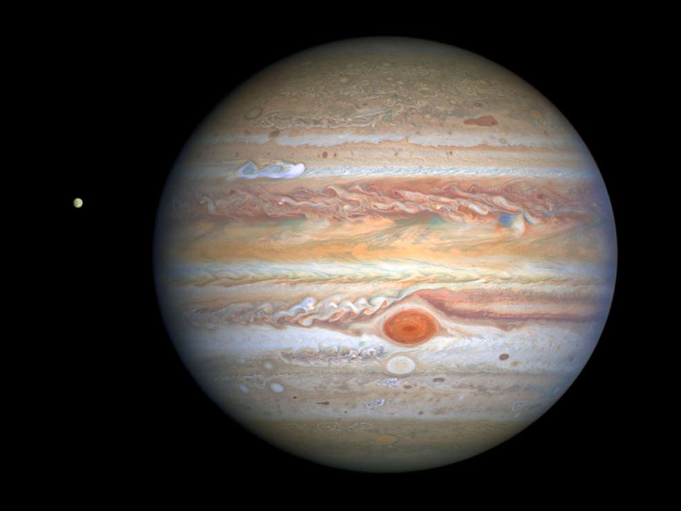 This latest image of Jupiter, taken by NASA’s Hubble Space Telescope on Aug. 25, 2020, was captured when the planet was 406 million miles from Earth. A unique and exciting detail of Hubble’s snapshot appears at mid-northern latitudes as a bright, white, stretched-out storm traveling around the planet at 350 mph. Hubble shows that the Great Red Spot, rolling counterclockwise in the planet’s southern hemisphere, is plowing into the clouds ahead of it, forming a cascade of white and beige ribbons. Jupiter’s icy moon Europa, thought to hold potential ingredients for life, is visible to the left of the gas giant.