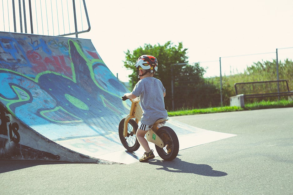 kid riding a bike up a skating ramp