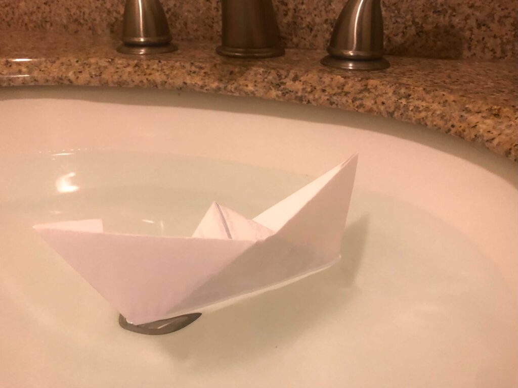 a paper boat in a sink