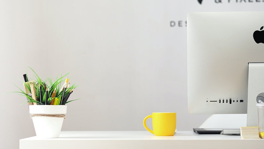desk with plant, mug, and computer