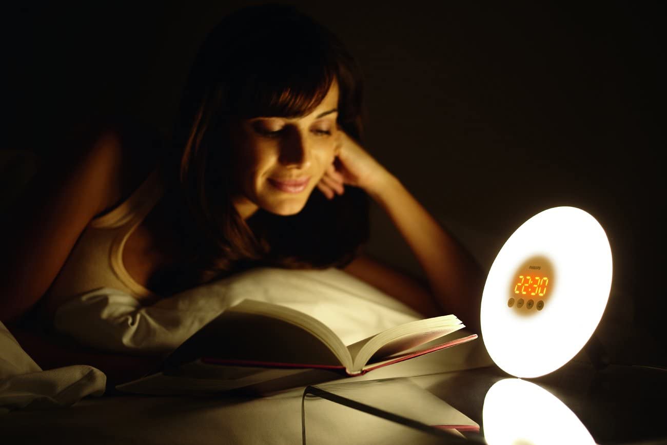 person reading next to a lamp