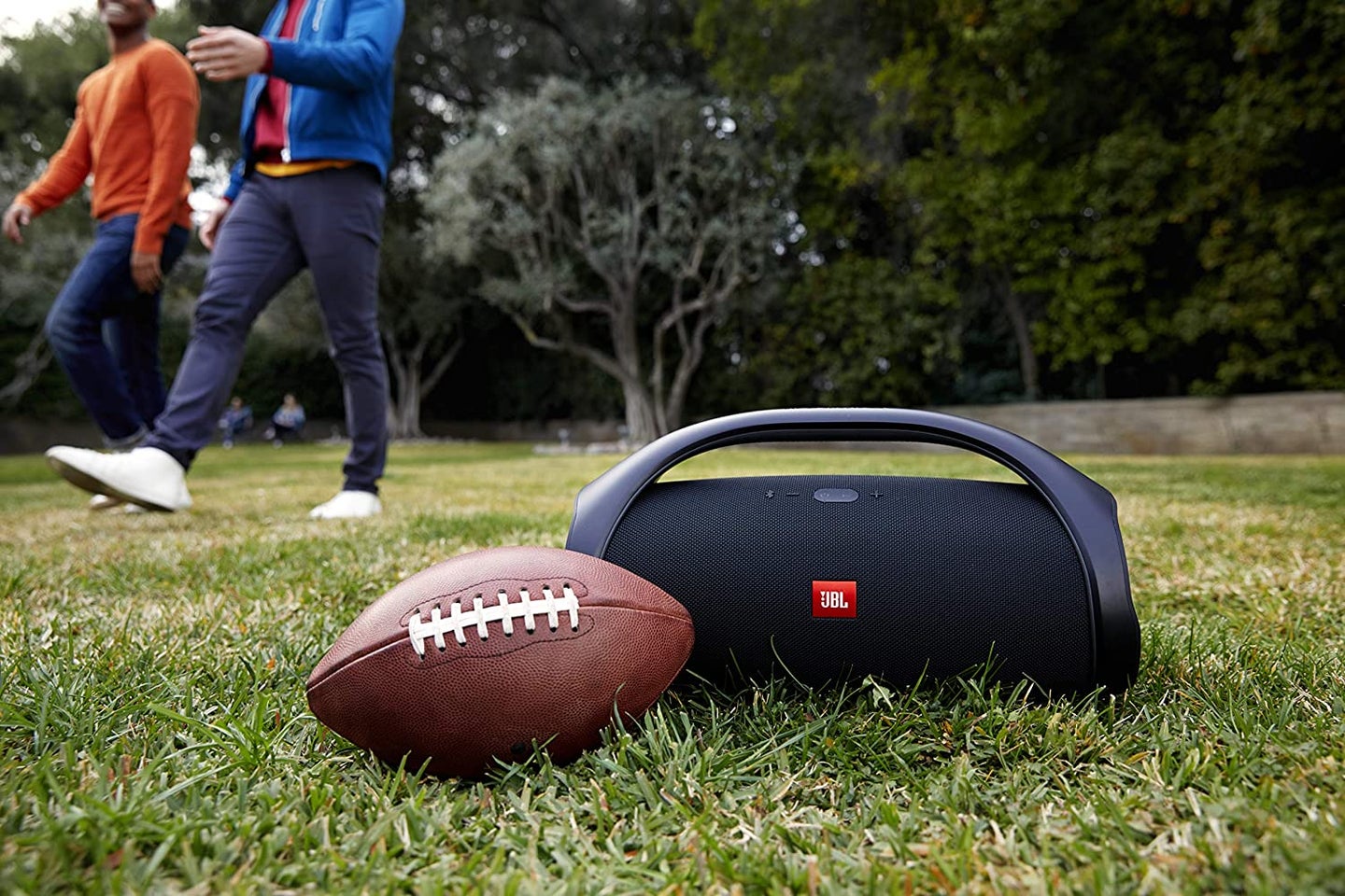 Bluetooth speaker and football in the grass