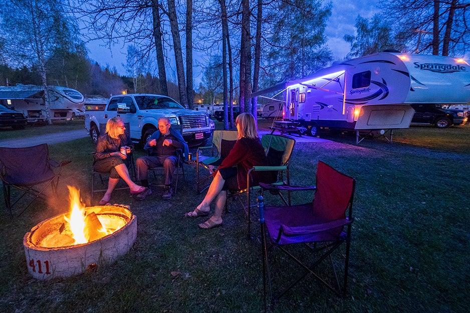 people sitting around a fire pit in chairs