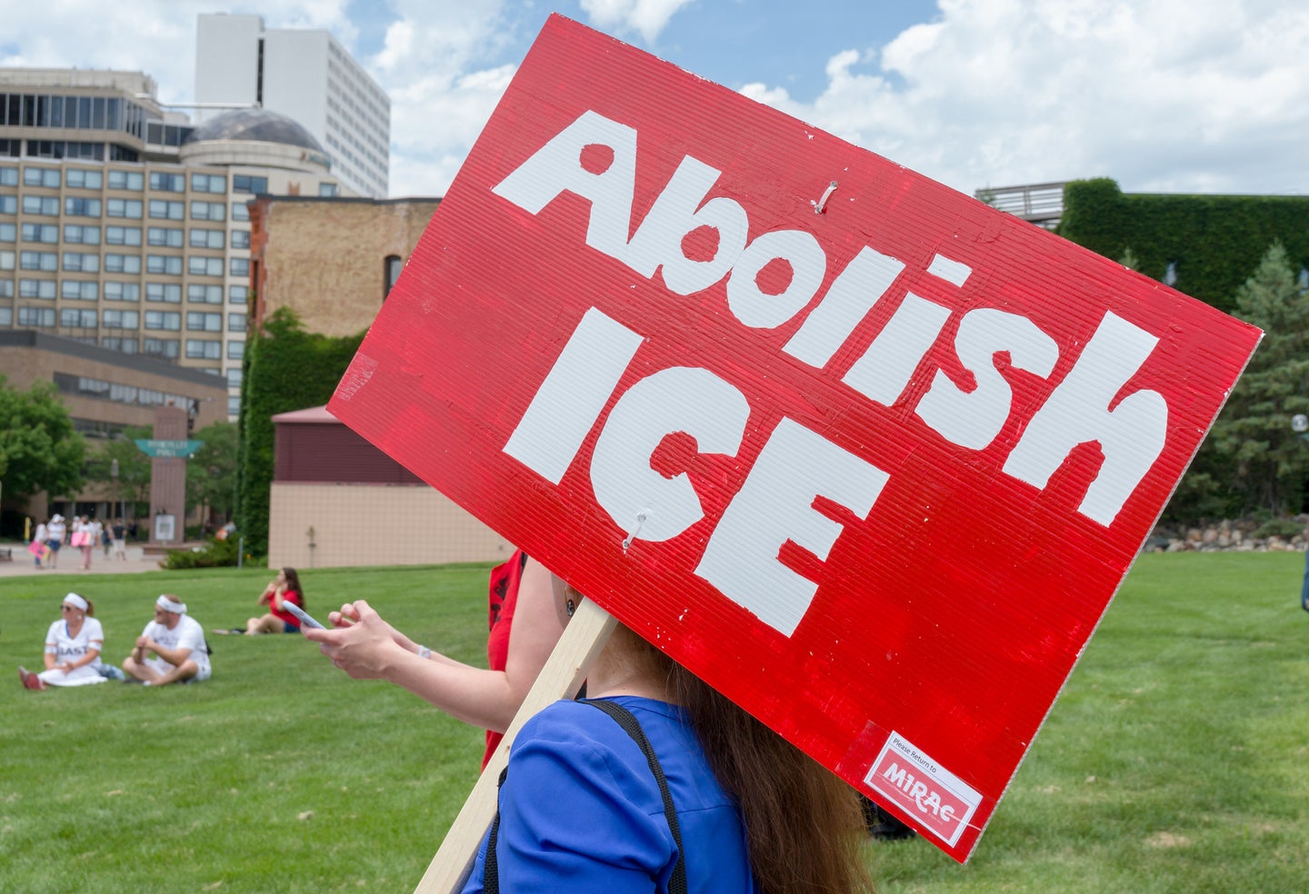 A protester holding an Abolish ICE sign