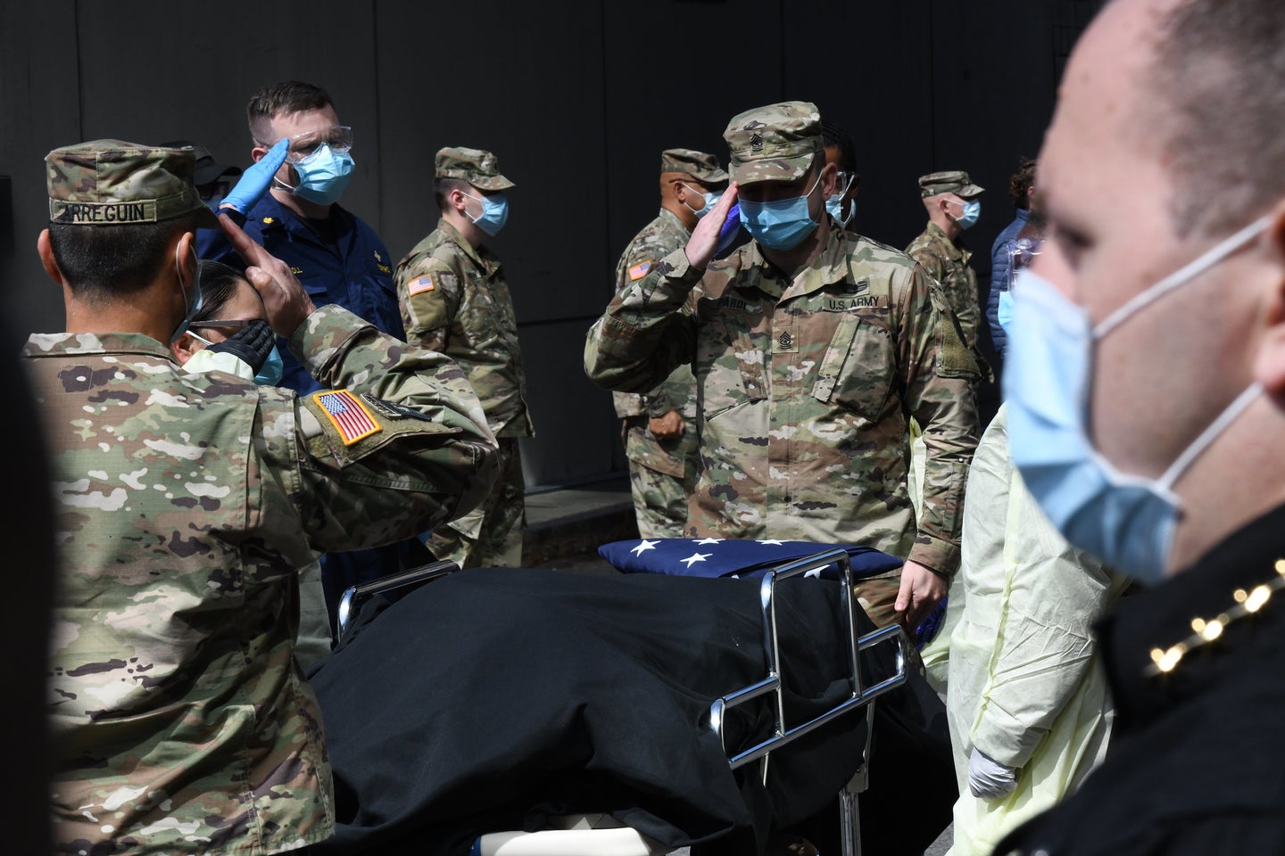 National guard members salute a veteran who died from COVID-19 at the Javits Center field hospital in New York City