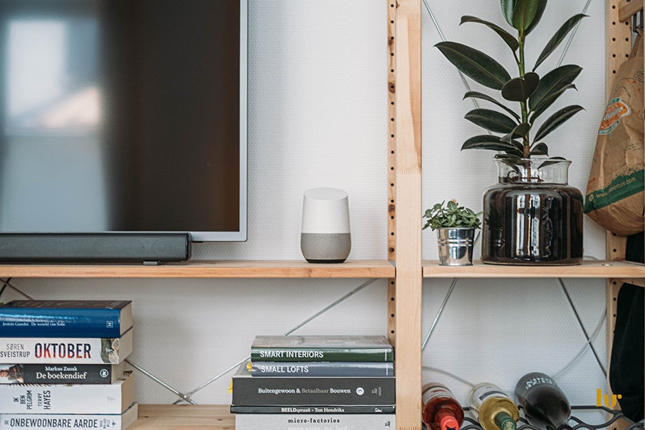 TV, smart speaker, wine, and books on a media console