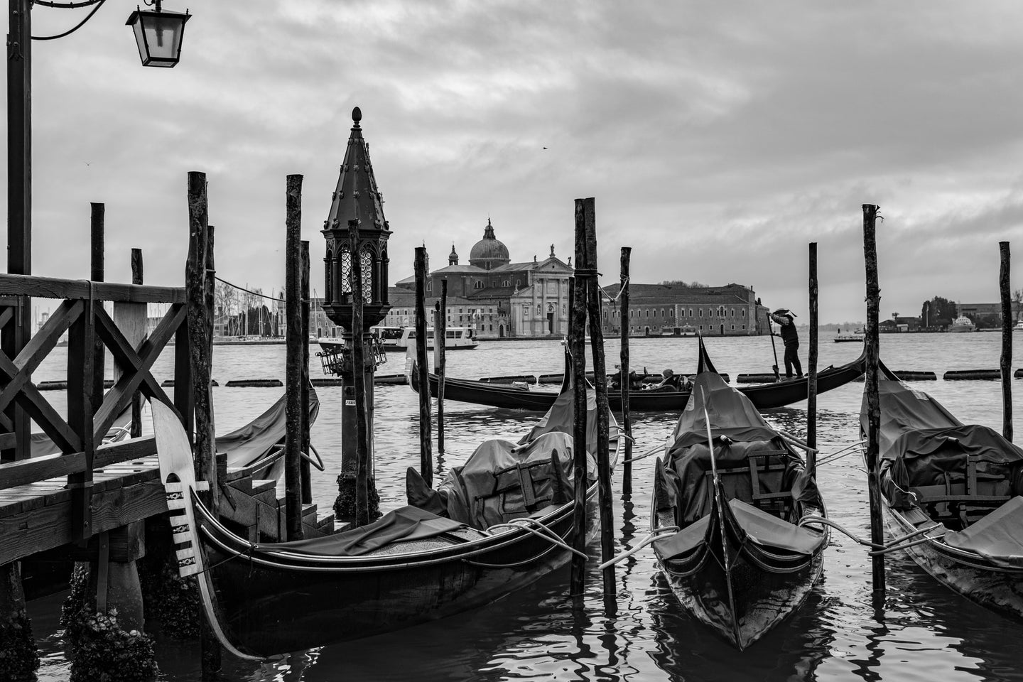 A black and white photo of gondolas in Venice