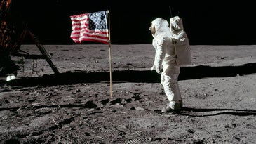 an astronaut stands next to an american flag on the moon