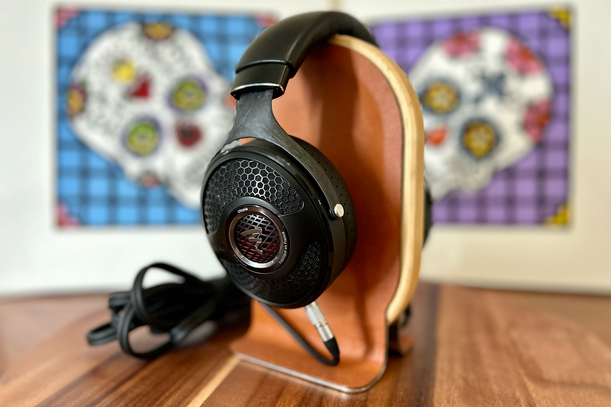 Focal Utopia 2022 headphones on a Grovemade stand in front of Amoroso skull art