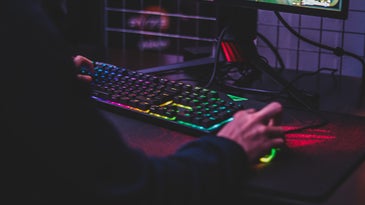Person using a gaming mouse and ergonomic keyboard.
