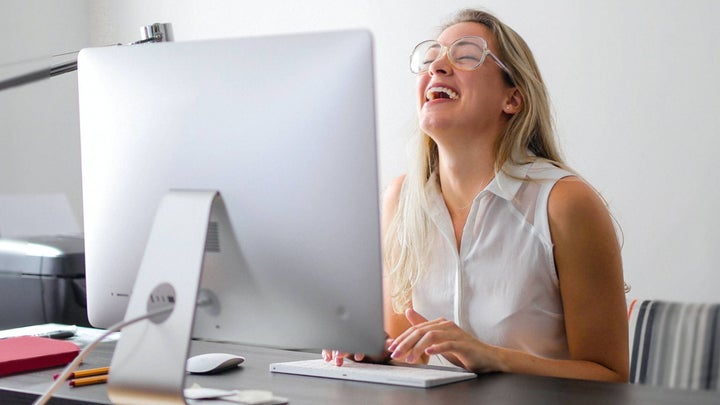 Person laughing at computer